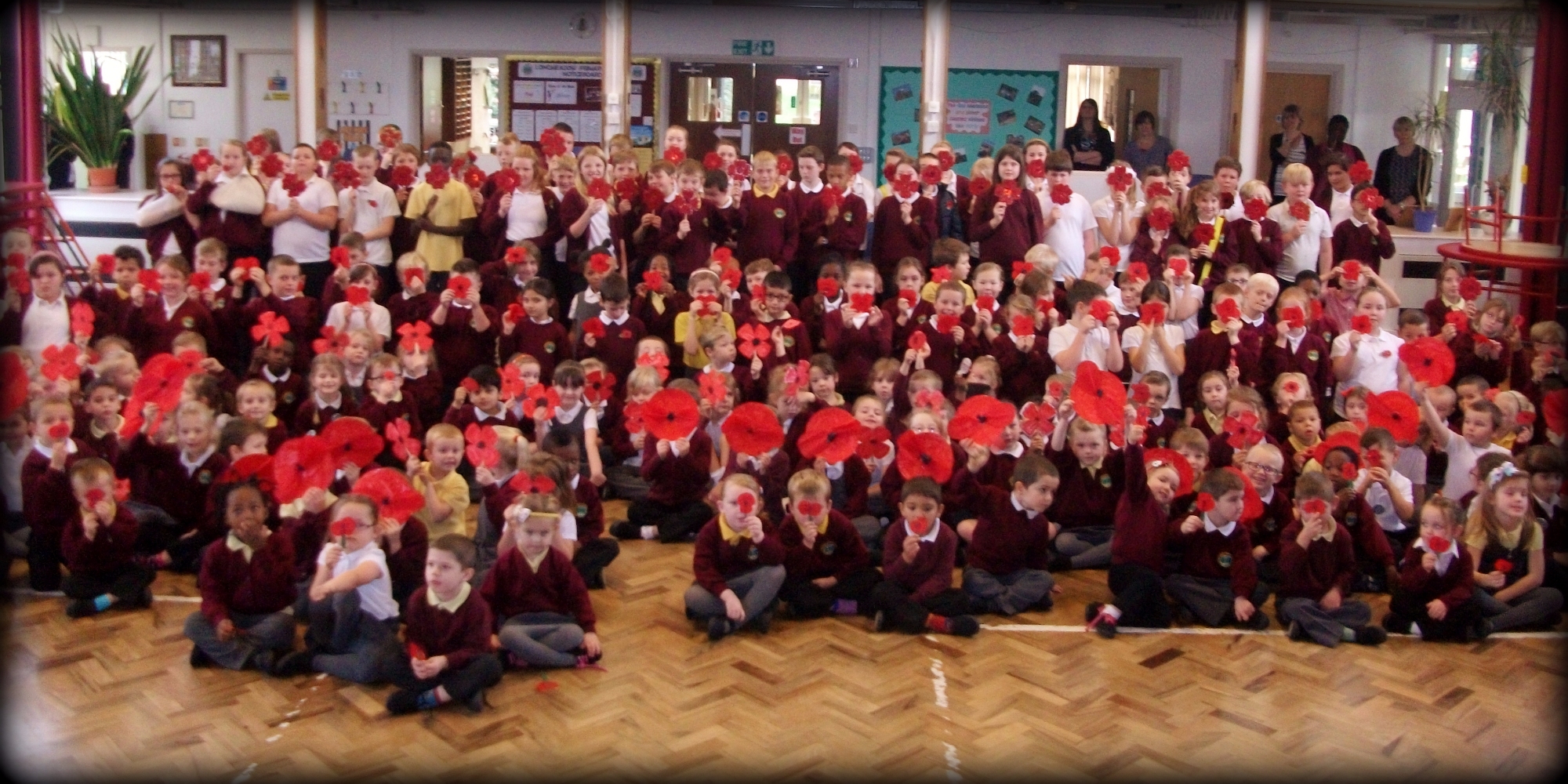 Whole school photo holding hand-made poppies.